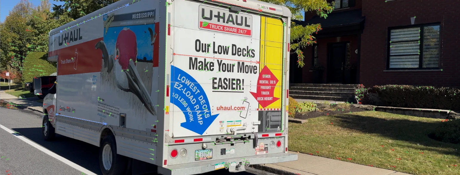 A truck in the viewer with guides drawn along its edges: red lines across its back (x), green up its corners (y), blue along its side (z), among the tracked points